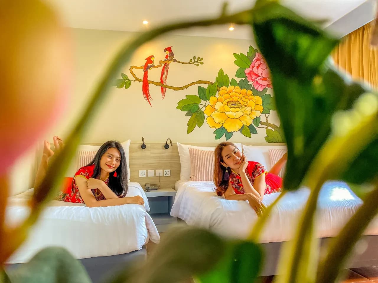 Sino House Phuket guest room with floral wall art